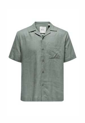 Chemise en lin vert à manches courtes avec un devant boutonné, un col évasé, une poche poitrine simple et une coupe décontractée. Détail de tissu texturé visible.