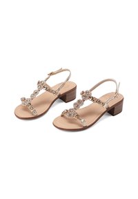 Sandali d'oro con cinturini e tacco basso a blocco. Presentano perline decorative sui cinturini e una soletta beige. Chiusura regolabile con fibbia alla caviglia.