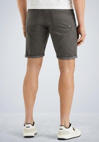 Dark grey shorts made of cotton blend, featuring rolled cuffs and standard pockets. Paired with white sneakers. Smooth texture.