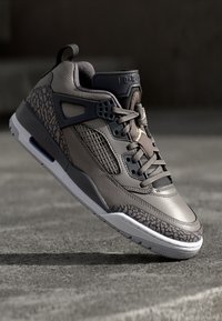 Sive sneakers s kožnim i teksturiranim detaljima, podstavljenim ovratnikom, mrežastim bočnim panelima i istaknutim uzorkovanim potplatima. Crno-bijeli detalji čim se primijete.