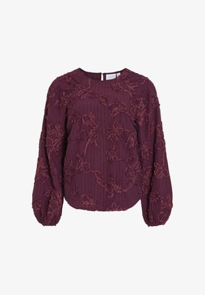 Burgundy blus med texturerad blommig broderi, ballongärmar, ribbat tyg och nyckelhålsstängning bak.