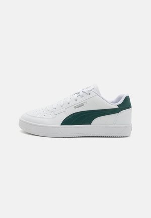 Sneaker bianchi con tomaia in pelle liscia, dettaglio verde di lato, punte perforate, lacci bianchi piatti e suola in gomma testurizzata.