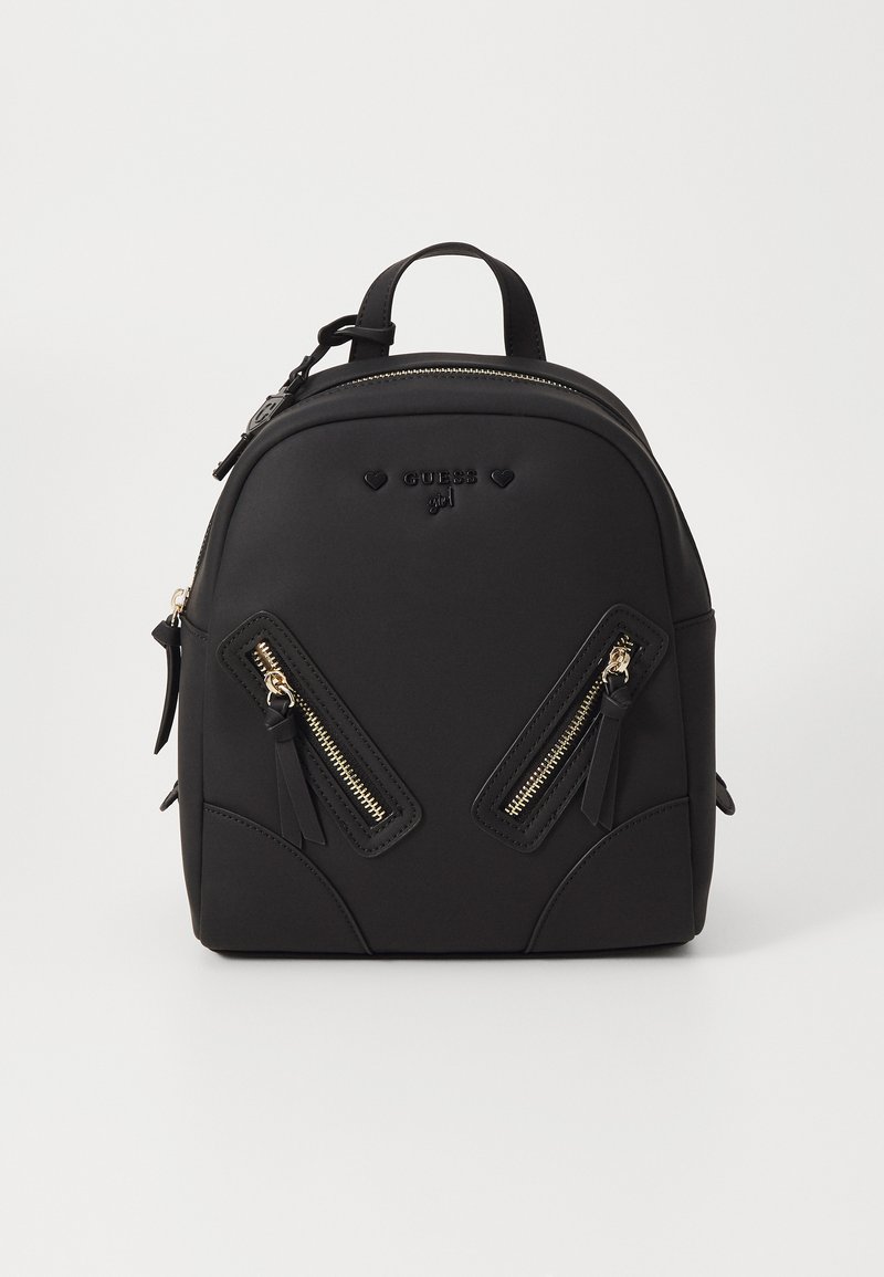 Sac à dos noir avec une texture lisse, doté de deux zips frontaux inclinés avec des accents dorés et d'une poignée supérieure. Logo de la marque embossé à l'avant.