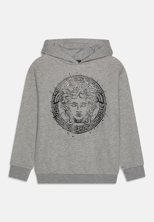 Pelēks sudraba vilnas kapuces džemperis ar centrālo melno grafiku, kurā attēlota Medūza dekoratīvā apļa rakstā. Ribota apkakle un apakšmala.