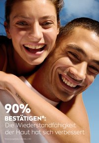Close-up of a man and woman smiling, showcasing clear skin. Natural light emphasizes their features against a blue sky background.