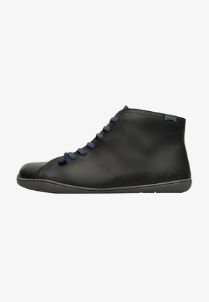Botas de cuero negro hasta el tobillo con punta redonda, que presentan cordones azul marino y un diseño minimalista; textura suave, suela flexible y un sutil logo.