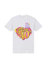 Biała bawełniana koszulka z kolorowym wzorem graficznym przedstawiającym niedźwiedzia, gwiazdy oraz napis "Care Bears 40th" w żółtym i różowym w kształcie serca.