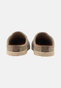 Brown felt slippers with an open back, featuring a textured sole and minimalistic design. Includes a small fabric tab on the heel.