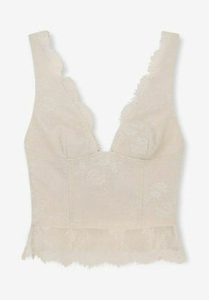 Top corto smanicato in pizzo beige con bordi smerlati e ricamo floreale, con scollo a V profondo.