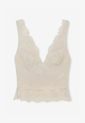Top corto smanicato in pizzo beige con bordi smerlati e ricamo floreale, con scollo a V profondo.