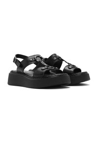 Sandali in pelle nera con suola platform, dotati di punte aperte, cinturini regolabili e decorazioni in metallo.