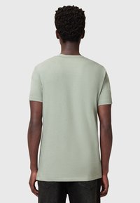 Camiseta de algodón de mangas cortas en verde claro con cuello redondo, que presenta una textura sutil y un corte relajado.