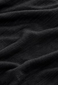 Black fabric with fine knit texture and subtle horizontal ribbing, shown in soft folds.