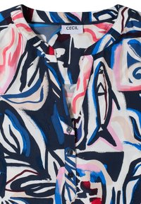Blouse sans col avec motif abstrait de coups de pinceau bleu marine, rose, bleu et beige, fermeture à boutons à l'avant, étiquette « Cecil » à l'intérieur du col.