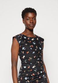 Vestido justo preto com padrão floral em azul claro, vermelho e bege. Design sem mangas com decote redondo e textura franzida na cintura.