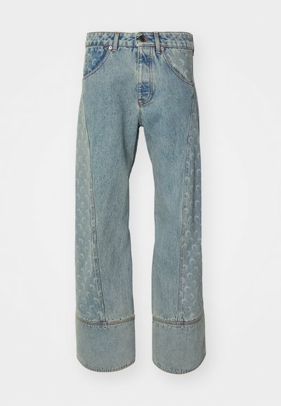 Jeans de mezclilla azul claro con pierna ancha, que presentan un panel lateral estampado y puños de mezclilla más oscuros en contraste. Diseño clásico de cinco bolsillos.