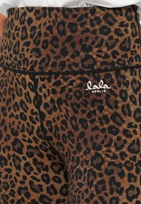 Leopárdmintás leggings barna és fekete anyagból, magas derékrésszel és egy kis "lala BERLIN" fehér logóval elöl.