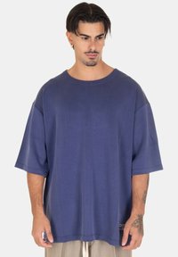 T-shirt oversize blu navy a maniche corte in un tessuto morbido, con collo a giro e un piccolo etichetta con logo sull'orlo.