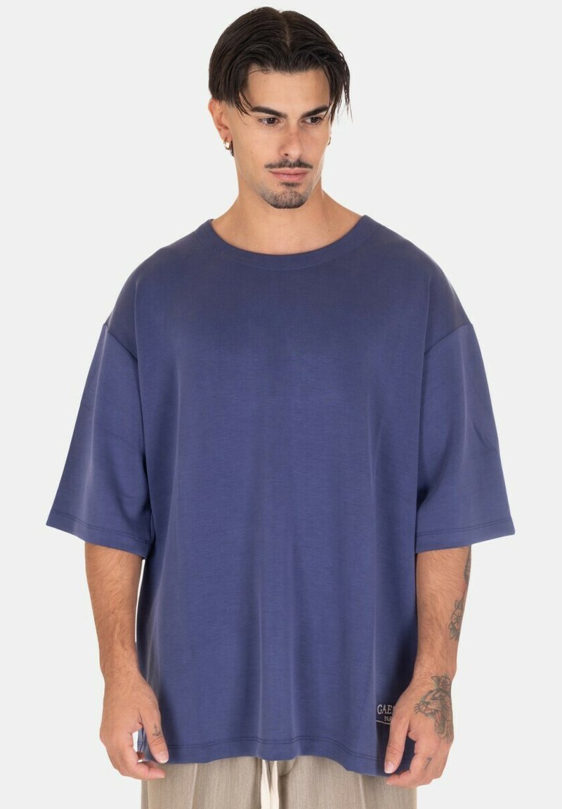 T-shirt oversize blu navy a maniche corte in un tessuto morbido, con collo a giro e un piccolo etichetta con logo sull'orlo.
