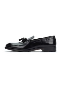 Mocasines de cuero negro con un acabado suave, punta redonda, borlas decorativas en la parte superior y un tacón bajo apilado para mayor estabilidad.