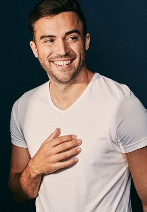 White V-neck T-shirt made of soft cotton, fitted design, short sleeves, and smooth texture. Light backdrop enhances the shirt's color.