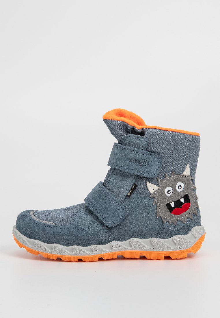 Grauer Wildlederstiefel mit orangen Akzenten und einem Klettverschluss. Verfügt über ein flauschiges Monster-Patch und eine strukturierte graue Sohle mit orangefarbenen Highlights.