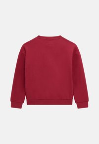 Felpa rossa con maniche lunghe, polsini e orlo a coste, texture liscia, design minimal e un piccolo etichetta sul collo dietro.