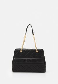 Sort quiltet lærveske med strukturert form, utstyrt med gullfargede kjedehåndtak og preget logo på et horisontalt bånd.