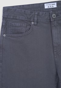 Szare dżinsy z subtelną diagonalną tekstur�ą, lekkim przetarciem, pięcioma kieszeniami i szlufkami na pasek, zapinane na guzik.