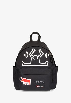 Mochila negra con gráfico blanco de Keith Haring, diseño rojo de perro y etiqueta de Eastpak. Cuenta con un bolsillo frontal y asa superior para llevar.