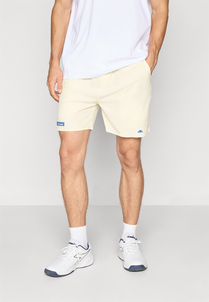 Shorts galbeni deschis, fabricate dintr-un material moale, având un brâu elastic, buzunare laterale și o etichetă cu logo albastră pe piciorul stâng.