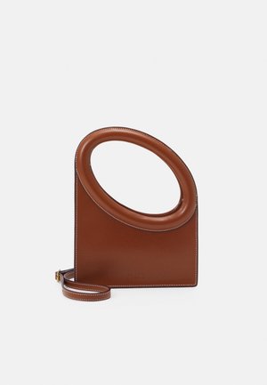 Braune Lederhandtasche mit großem rundem Griffausschnitt und abnehmbarem Riemen vor weißem Hintergrund.