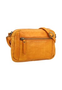 Mala od narančaste kože, s remenom za crossbody nošenje, prednjim zip džepom i podesivim remenom s metalnom kopčom, izolirana na bijeloj pozadini.