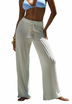 Pantalons de plage légers, de couleur crème, tricotés, avec une taille à cordon et un détail de pompon, présentant une coupe ample et large ainsi qu'un motif texturé.