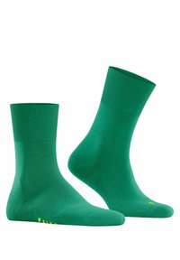 Grüne Knöchelsocken mit gerippten Bündchen, nahtloser Zehenpartie und glatter Textur. Mit kleinem gelbem Branding an der Sohle.
