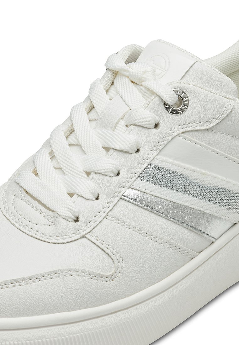 Białe sneakersy z górną częścią z teksturowanej skóry, srebrnym akcentem na pasku i płaskimi białymi sznurówkami. Posiadają okrągłe oczko i teksturowaną gumową podeszwę.