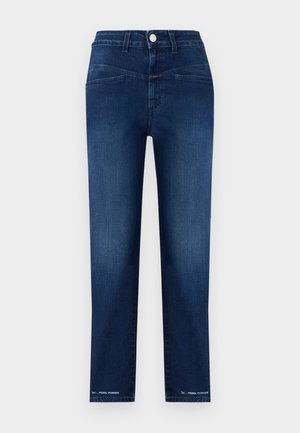 Tamsiai mėlynos tiesios kojų džinsai su priekiniais mygtukais, matomomis siūlėmis ir užrašu „PEDAL PUSHER“ šalia apačios abiejose kojose.