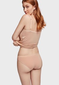 Lichtgewicht, huidkleurig tanktop met dunne schouderbandjes, gecombineerd met bijpassend bikini-ondergoed. Glad textuur en aansluitend ontwerp.