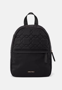 Mochila acolchada negra de nylon, con correas ajustables, un bolsillo frontal con cremallera y un logo dorado en la parte inferior frontal.