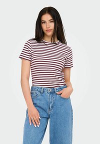 Gestreept t-shirt in kastanjebruine en witte kleuren, met korte mouwen en een ronde halslijn, gecombineerd met high-waisted blauwe denim jeans.