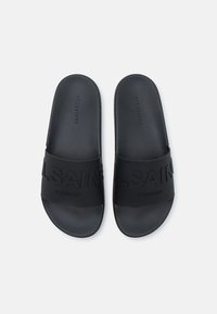 Sandales noires à glisser, en caoutchouc texturé, avec une large sangle embossée "ALLSAINTS LONDON" et une semelle intérieure lisse.