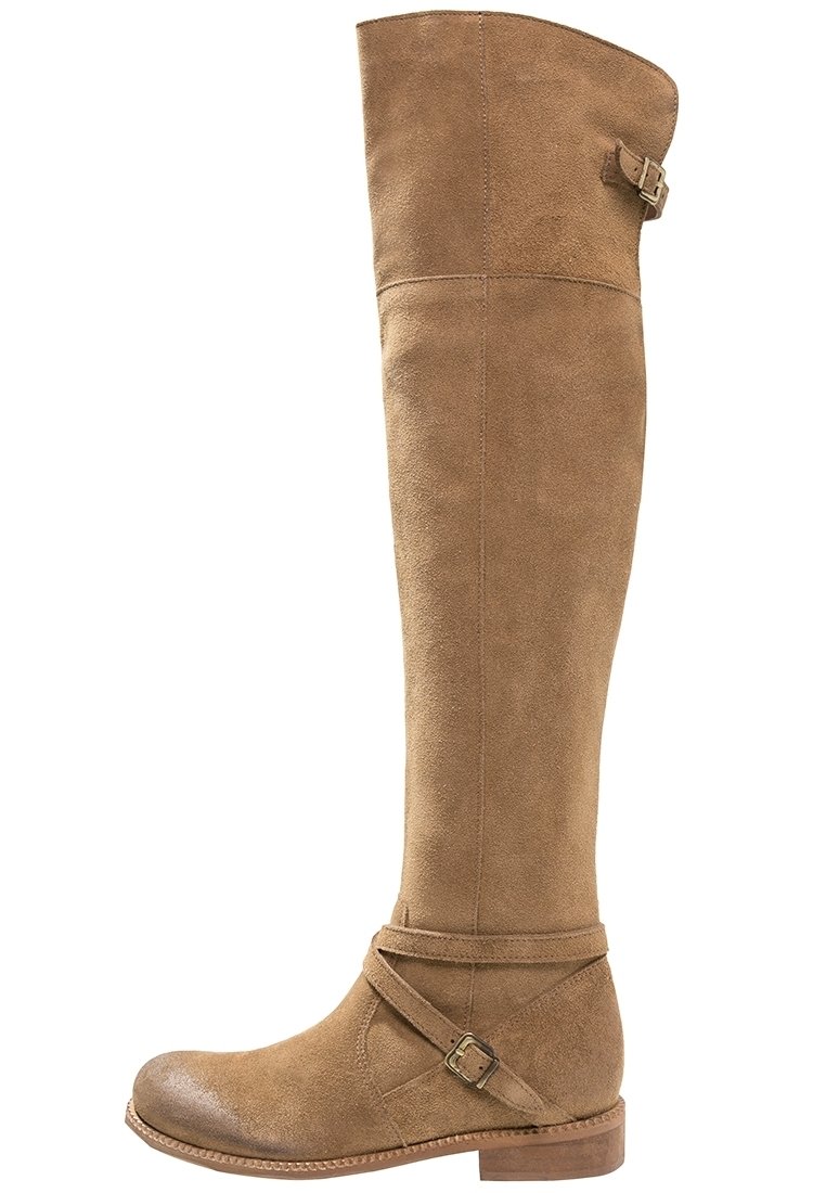 Tan suede over-the-knee boots with a rounded toe, low stacked heel, and a decorative buckle with a cross-strap at the ankle.