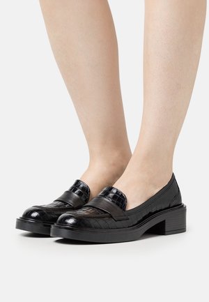 Mocassins en cuir noir avec un motif texturé crocodile, semelle plate et détail lisse sur le devant. Convient pour une utilisation formelle ou décontractée.