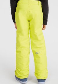 Pantaloni da sci gialli con una vestibilità rilassata, realizzati in materiale resistente all'acqua. Presentano un logo sulla parte inferiore della gamba e orli rinforzati per una maggiore durata.