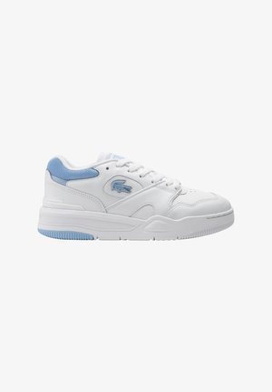 Zapatilla baja blanca y azul claro con diseño de cordones y suela texturizada, con un pequeño logo de cocodrilo en el lateral.