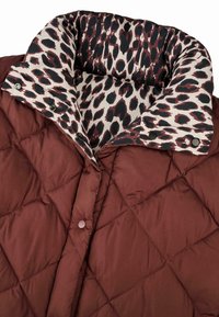 Hnedá prešívaná bunda s vnútorným golierom s leopardím vzorom. Má zapínanie na patentky a hladký, lesklý povrch.
