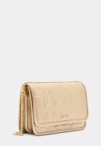 Sac à épaule texturé beige avec logo en relief, doté d'une fermeture à rabat et d'une chaîne dorée. Matériau lisse avec un éclat subtil.