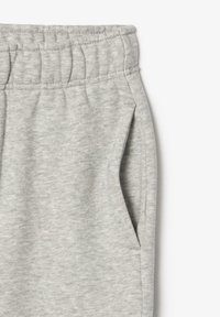 Pantalon de survêtement gris avec une taille élastique, des poches latérales et une finition douce et texturée, présentant un motif de tissu chiné.