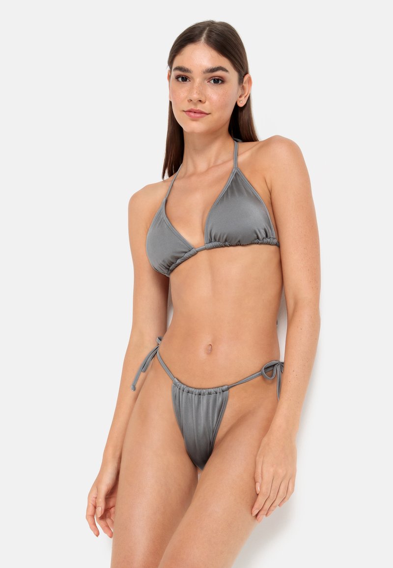 Bikini triangle gris à halter en tissu lisse et brillant. Doté de côtés à nouer ajustables et d'une couvrance minimale pour le bas.