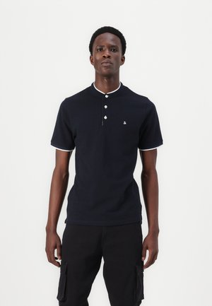 Marineblauwe polo shirt van katoen met een kraag, drieknoopsluiting en witte accenten op de kraag en de mouwen. Klein logo op de borst.
